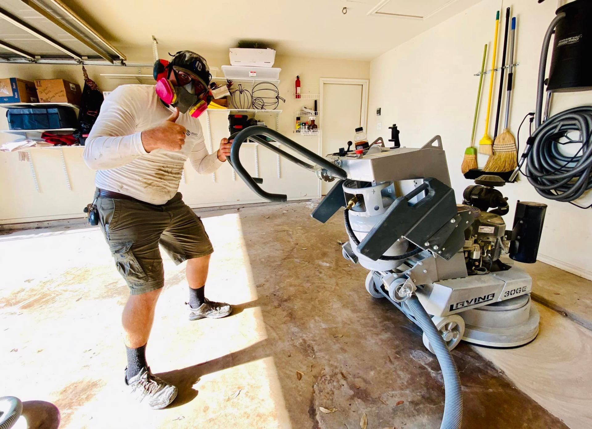 Legacy team member working in residential garage with professional floor coating equipment
