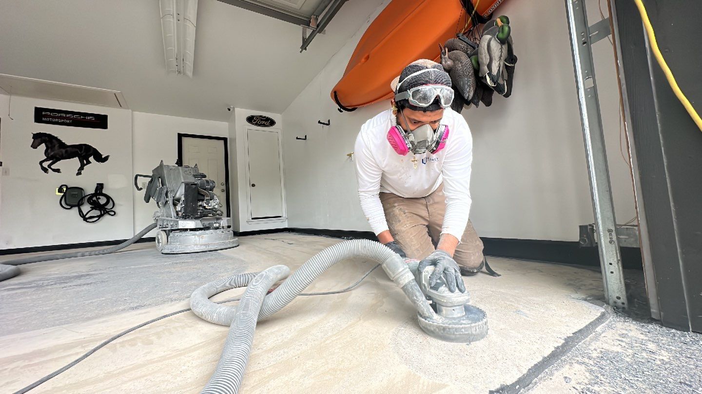 Legacy craftsman carefully preparing garage floor surface with professional equipment